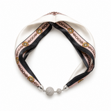 A silk scarf headband with a twisted knot design, featuring a white satin base, a pink and brown chain pattern, and silver-tone crystal-embellished beads at the front closure, shown on a plain white background.