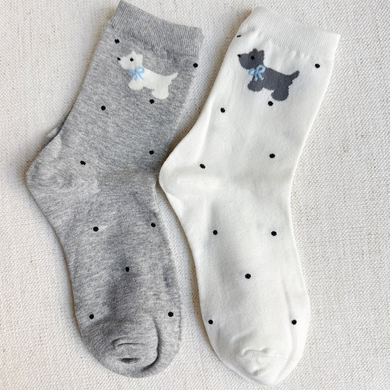 Crew-length socks featuring a charming Scottie dog pattern, designed in two coordinated colorways. The Scottie silhouettes are playfully on each sock, creating a fun and cozy look perfect for dog lovers and everyday wear.