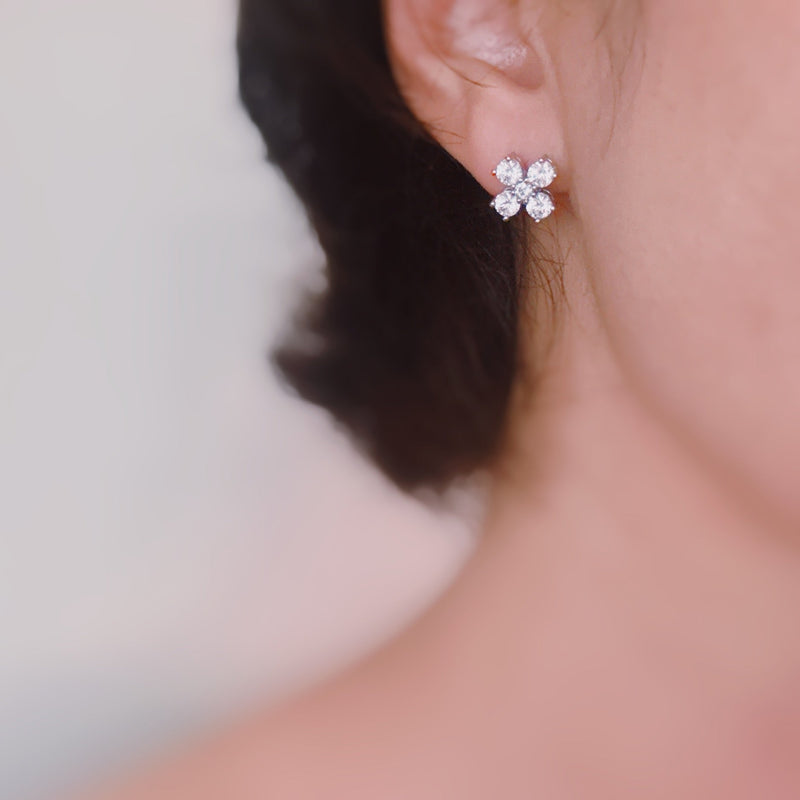 Silver-tone stud earrings in a floral clover shape, each featuring four pear-shaped cubic zirconia stones arranged in a symmetrical pattern for a radiant and delicate sparkle.