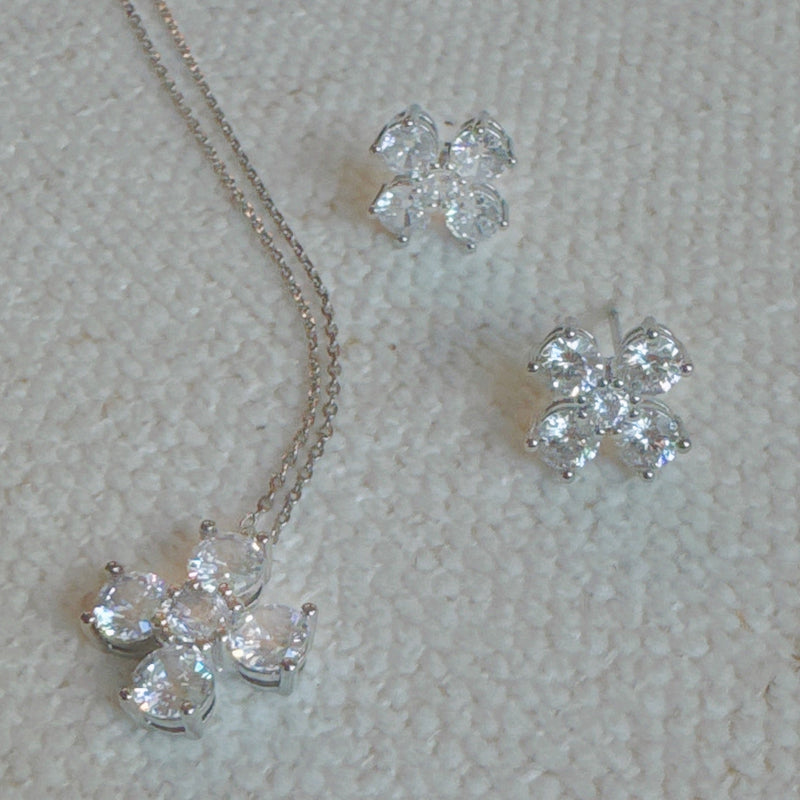 Silver-tone stud earrings in a floral clover shape, each featuring four pear-shaped cubic zirconia stones arranged in a symmetrical pattern for a radiant and delicate sparkle.