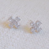 Silver-tone stud earrings in a floral clover shape, each featuring four pear-shaped cubic zirconia stones arranged in a symmetrical pattern for a radiant and delicate sparkle.