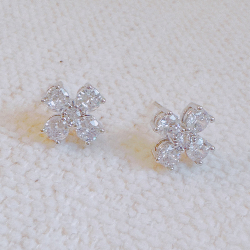 Silver-tone stud earrings in a floral clover shape, each featuring four pear-shaped cubic zirconia stones arranged in a symmetrical pattern for a radiant and delicate sparkle.