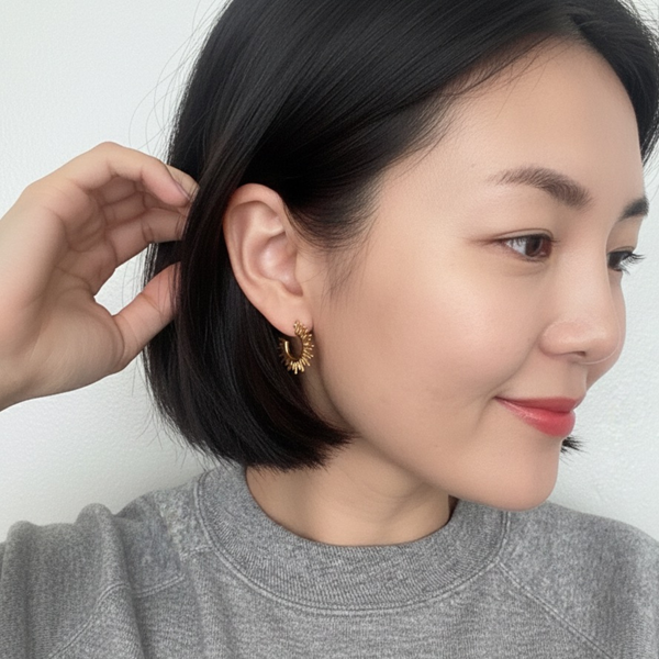 Set of small hoop earrings with radiating sunburst-inspired design in gold finishes