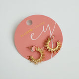 Set of small hoop earrings with radiating sunburst-inspired design in gold finishes