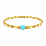 Gold beaded bracelet with a turquoise heart charm on a white background