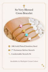 Gold cross bracelet with colorful charms on a wrist, set against a neutral background.