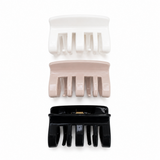 Three hair clips in white, beige, and black on a white background