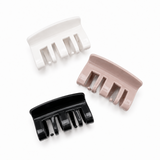 Three hair combs in black, white, and pink on a white background