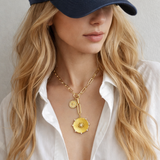 Gold necklace featuring two radiant sunburst medallions accented with sparkling crystals. The Sunbeam Medallion Necklace showcases a modern vintage glow with layered coin charms and a sleek link chain for timeless sophistication.