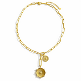 Gold necklace featuring two radiant sunburst medallions accented with sparkling crystals. The Sunbeam Medallion Necklace showcases a modern vintage glow with layered coin charms and a sleek link chain for timeless sophistication.