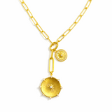 Gold necklace featuring two radiant sunburst medallions accented with sparkling crystals. The Sunbeam Medallion Necklace showcases a modern vintage glow with layered coin charms and a sleek link chain for timeless sophistication.