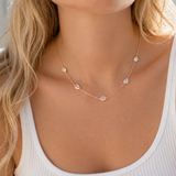 Necklace with small diamonds on a person wearing a white top