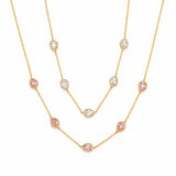 Gold necklace with pink and clear gemstones on a white background