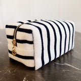 Soft terry cloth cosmetic case featuring bold, horizontal stripes and a compact zippered design—perfect for storing makeup, toiletries, or small travel essentials with a cozy, beach-ready flair.