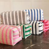 Soft terry cloth cosmetic case featuring bold, horizontal stripes and a compact zippered design—perfect for storing makeup, toiletries, or small travel essentials with a cozy, beach-ready flair.