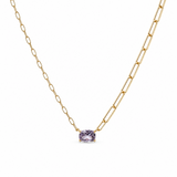 Gold necklace with a purple gemstone on a white background