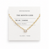 Gold necklace with a diamond pendant on a 'The Month Code' card.