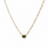 Gold chain necklace with a green gemstone on a white background