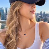 Woman wearing a white tank top and blue cap with a cityscape in the background