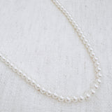 Elegant white beaded necklace with a timeless design and gold clasp