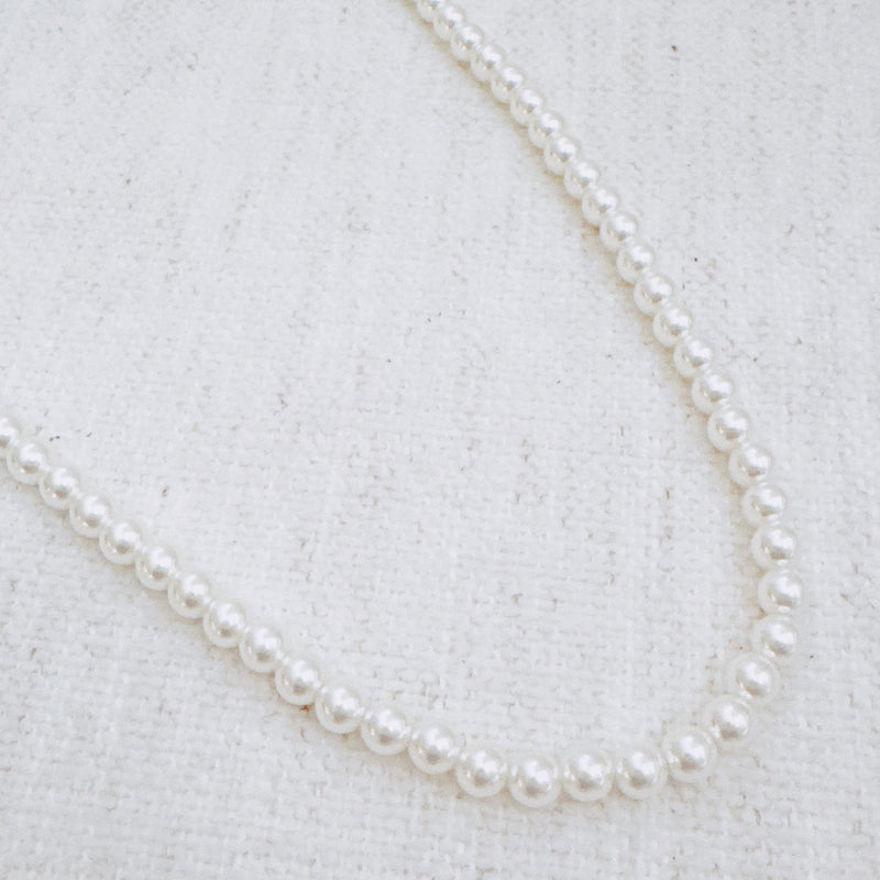 Elegant white beaded necklace with a timeless design and gold clasp