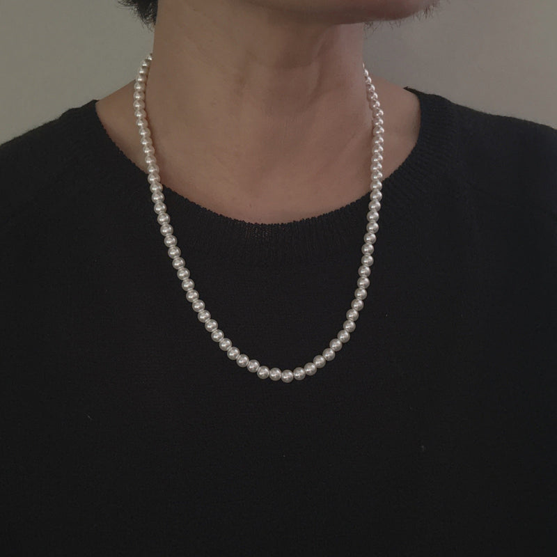 Elegant white beaded necklace with a timeless design and gold clasp