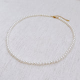Elegant white beaded necklace with a timeless design and gold clasp