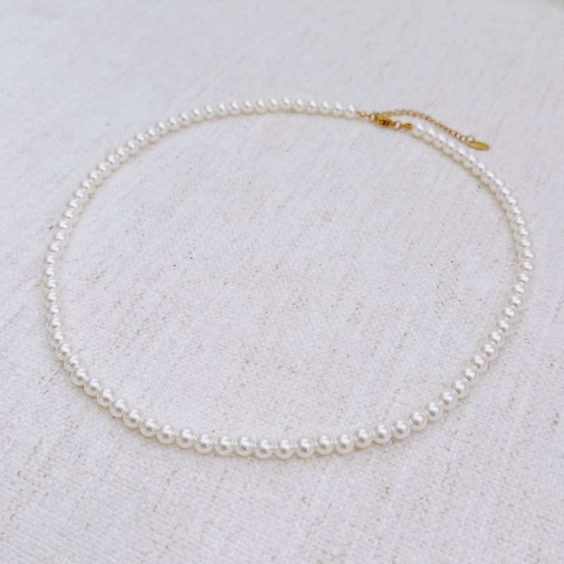Elegant white beaded necklace with a timeless design and gold clasp