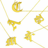 Gold-tone chain necklace featuring a bold Gothic-style initial charm that hangs asymmetrically to the side, adding a vintage-inspired yet edgy detail to your layered look.
