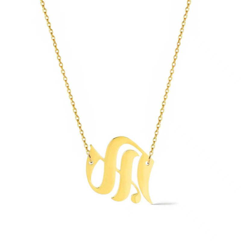 Gold-tone chain necklace featuring a bold Gothic-style initial charm that hangs asymmetrically to the side, adding a vintage-inspired yet edgy detail to your layered look.