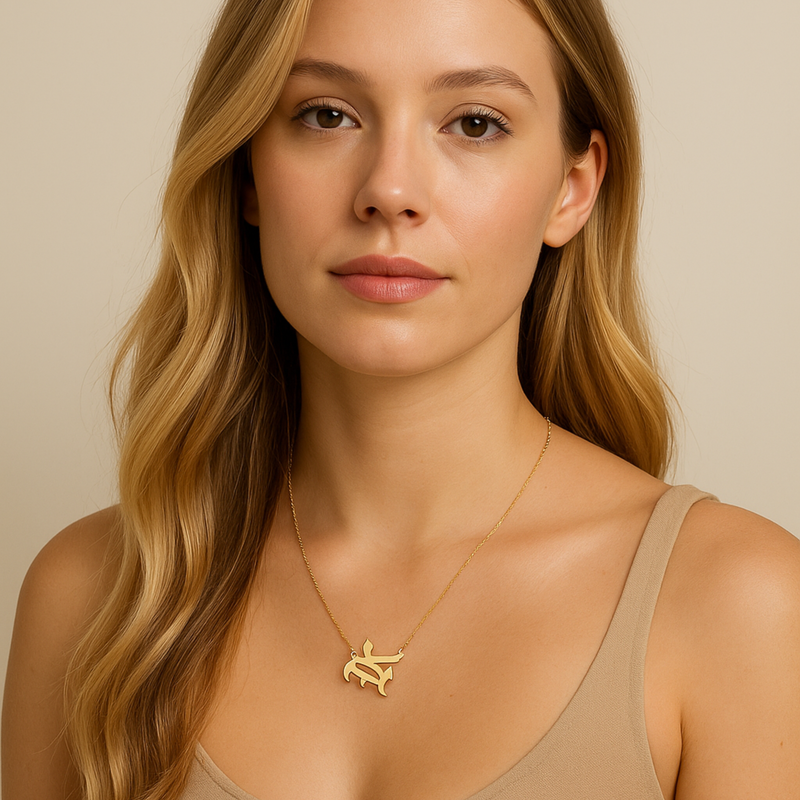 Gold-tone chain necklace featuring a bold Gothic-style initial charm that hangs asymmetrically to the side, adding a vintage-inspired yet edgy detail to your layered look.