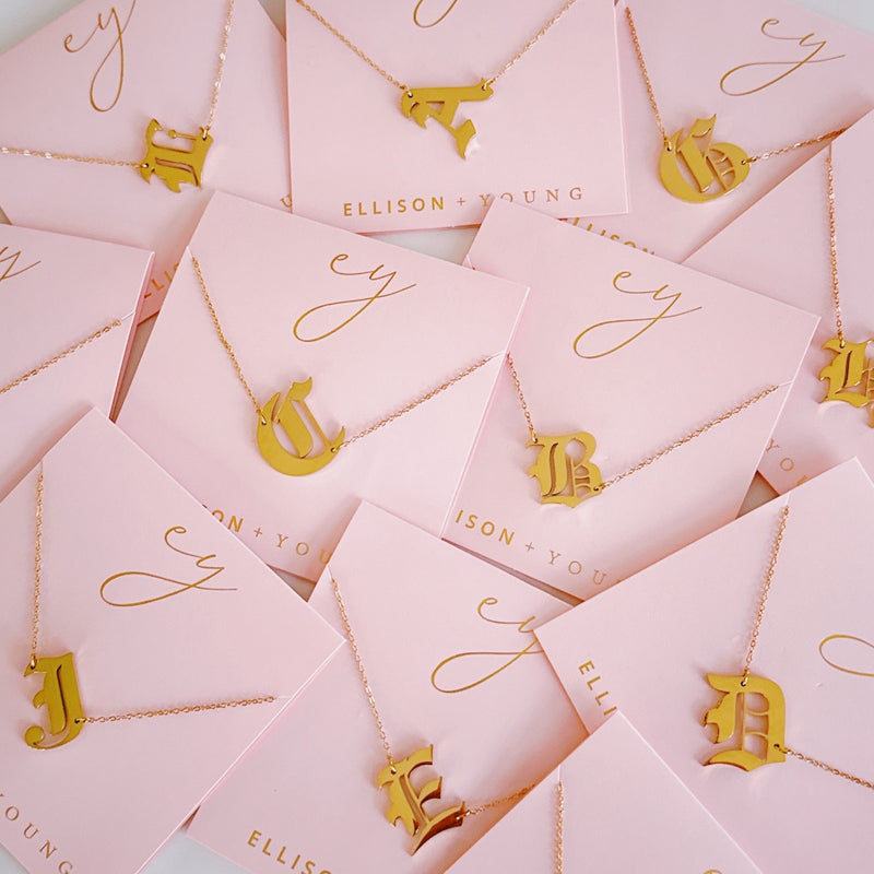 Gold-tone chain necklace featuring a bold Gothic-style initial charm that hangs asymmetrically to the side, adding a vintage-inspired yet edgy detail to your layered look.