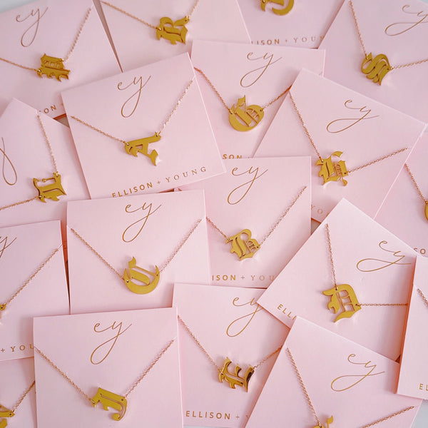 Gold-tone chain necklace featuring a bold Gothic-style initial charm that hangs asymmetrically to the side, adding a vintage-inspired yet edgy detail to your layered look.