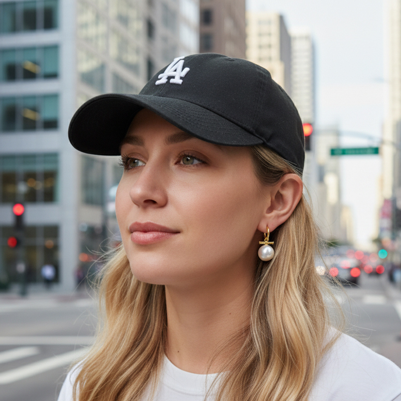 Sleek gold-tone toggle bar earrings featuring a lustrous pearl drop, blending modern structure with timeless charm for a refined, fashion-forward statement.