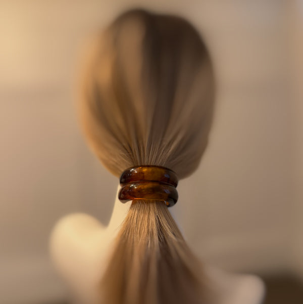 Stylish hair tie featuring a glossy tortoise-shell dome accent—perfect for adding a chic, polished touch to ponytails or buns.