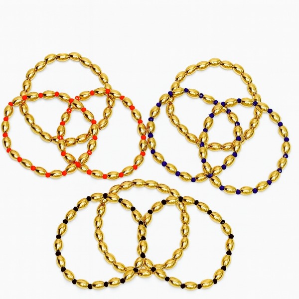 Three sets of glossy gold-tone oval bead stretch bracelets, each accented with different colored spacer beads in red, navy, or black; each set includes three coordinating bracelets.