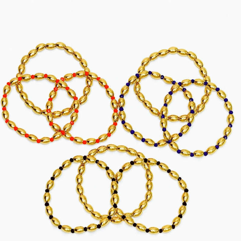 Three sets of glossy gold-tone oval bead stretch bracelets, each accented with different colored spacer beads in red, navy, or black; each set includes three coordinating bracelets.