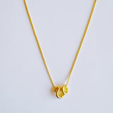 Elegant necklace featuring a trio of oval-shaped pendants in varying sizes, each with a polished, minimal design. The pendants are arranged in a vertical drop on a delicate chain, creating a modern and refined layered look. Perfect for both everyday wear and special occasions.