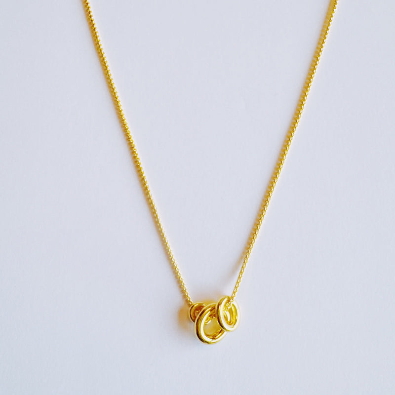 Elegant necklace featuring a trio of oval-shaped pendants in varying sizes, each with a polished, minimal design. The pendants are arranged in a vertical drop on a delicate chain, creating a modern and refined layered look. Perfect for both everyday wear and special occasions.