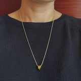 Elegant necklace featuring a trio of oval-shaped pendants in varying sizes, each with a polished, minimal design. The pendants are arranged in a vertical drop on a delicate chain, creating a modern and refined layered look. Perfect for both everyday wear and special occasions.