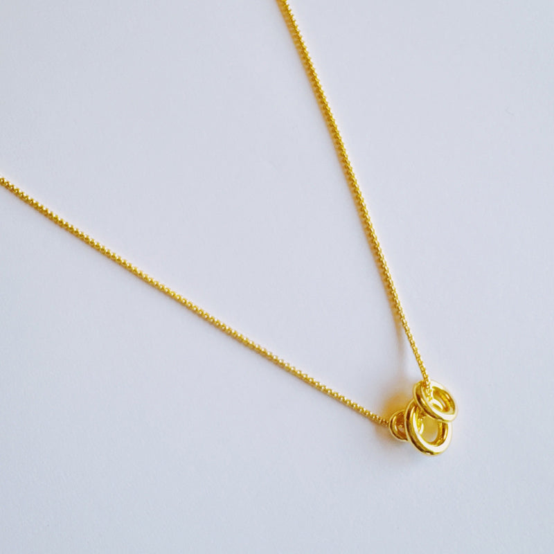 Elegant necklace featuring a trio of oval-shaped pendants in varying sizes, each with a polished, minimal design. The pendants are arranged in a vertical drop on a delicate chain, creating a modern and refined layered look. Perfect for both everyday wear and special occasions.