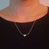 Delicate two-tone necklace featuring a petite heart pendant with a metal finish on a fine chain.