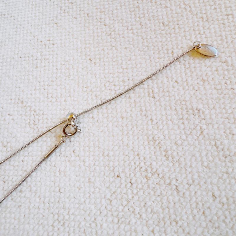 Delicate two-tone necklace featuring a petite heart pendant with a metal finish on a fine chain.