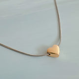 Delicate two-tone necklace featuring a petite heart pendant with a metal finish on a fine chain.