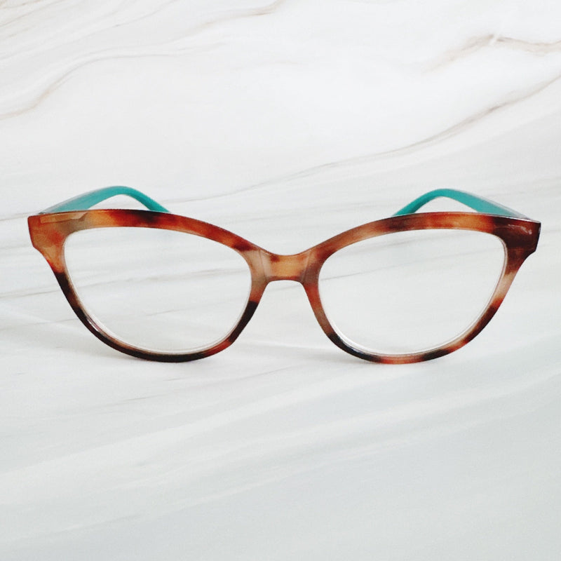 Cat-eye glasses with tortoiseshell frame and teal arms on a white background