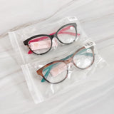 Two pairs of eyeglasses in clear packaging