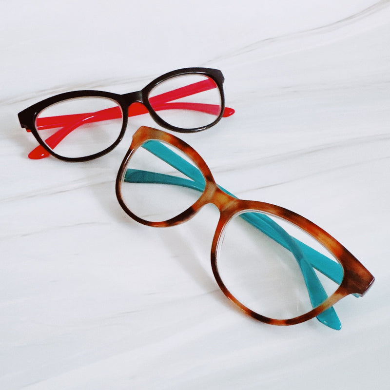 Two pairs of eyeglasses with colorful temple tips on a white background