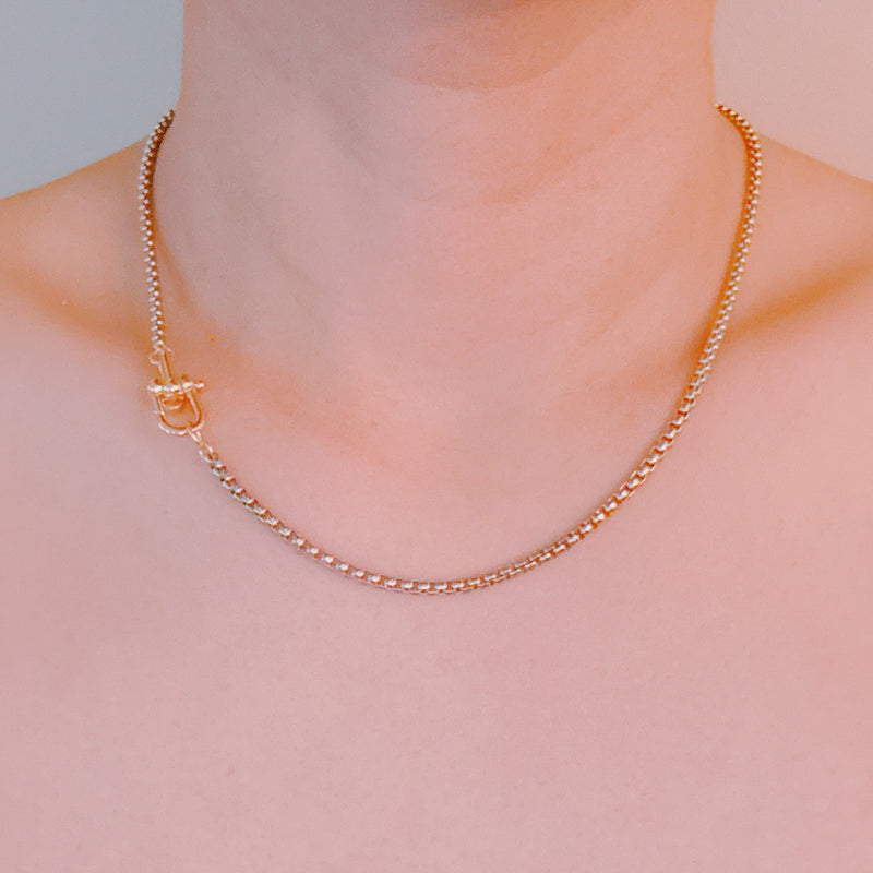 Silver-tone U-link chain necklace featuring a bold, gold lock pendant for a modern, edgy statement.