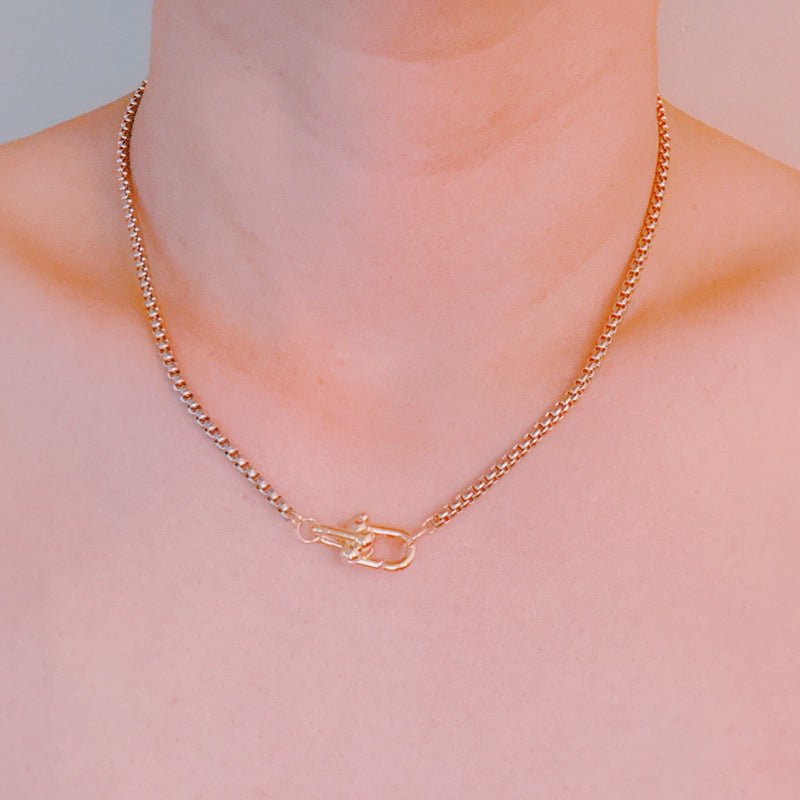 Silver-tone U-link chain necklace featuring a bold, gold lock pendant for a modern, edgy statement.