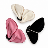 Three butterfly-shaped fabric face masks in cream, pink, and black velvet, arranged on a clean white background.